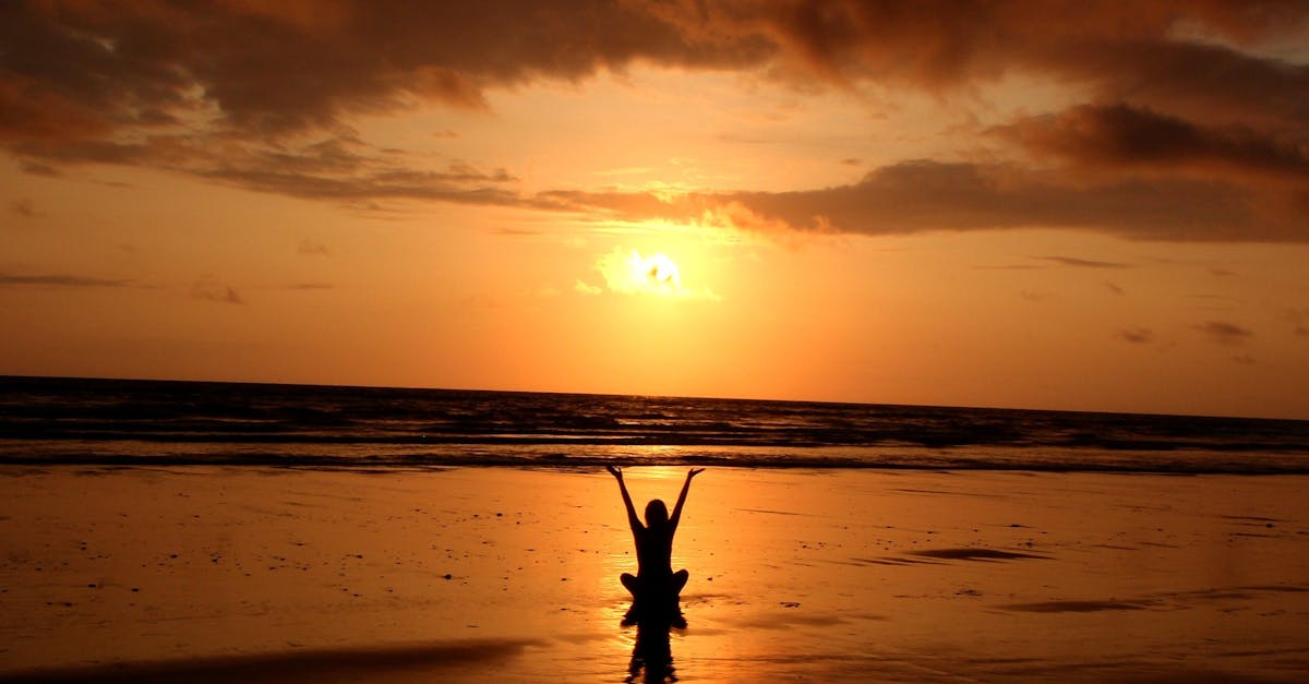 Peaceful meditation silhouette at sunset on a serene beach.