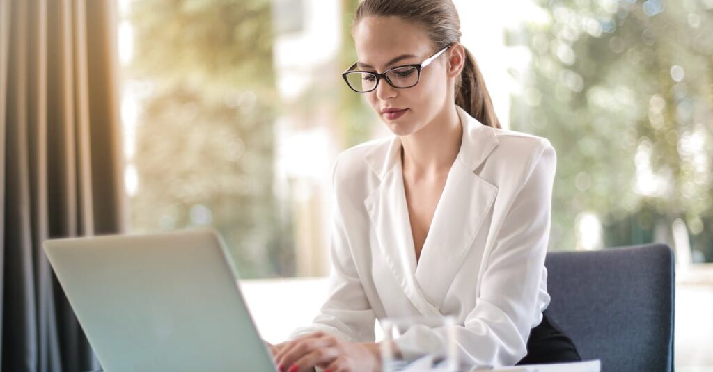 Confident businesswoman using a laptop at her desk, focused on her work.