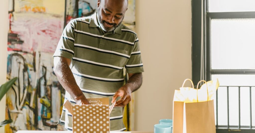 Smiling man carefully opens Father's Day gifts in a sunny indoor setting with abstract art.