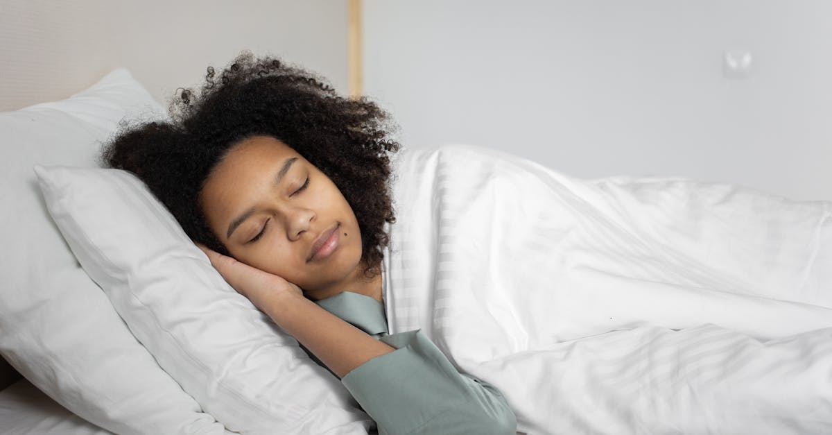 A serene scene of a woman with afro hair peacefully sleeping in a cozy bedroom.
