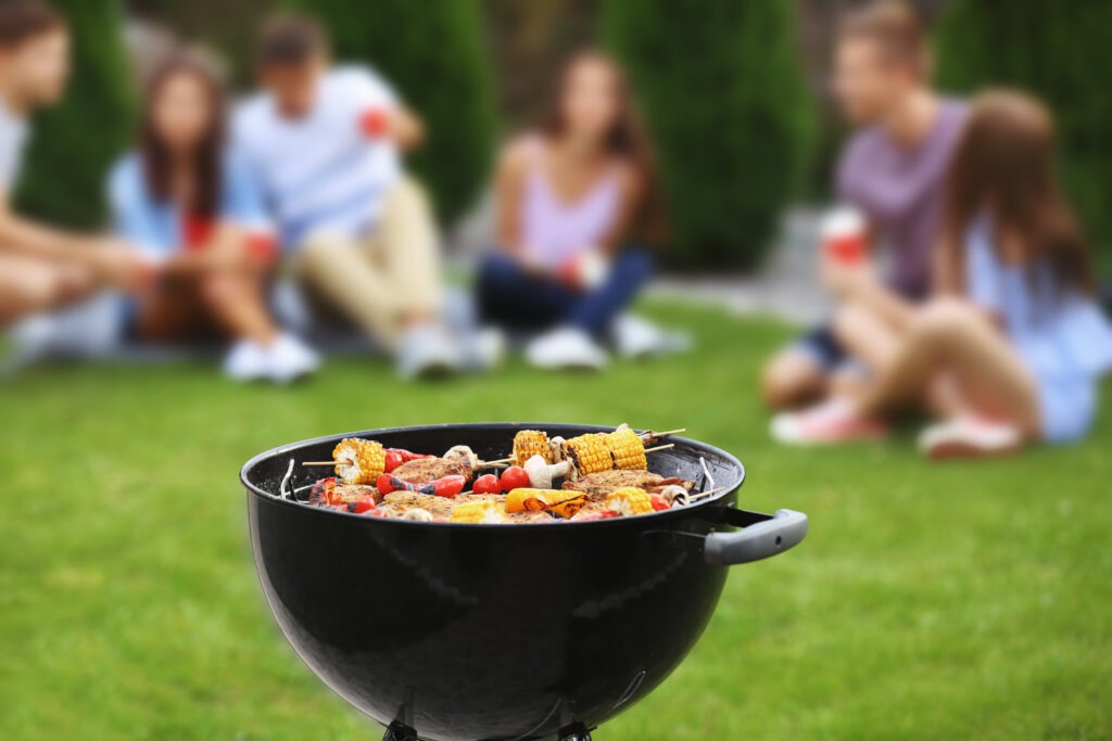 Tasty steaks and vegetables cooking on BBQ grill, outdoors. Prime Day grill deals.