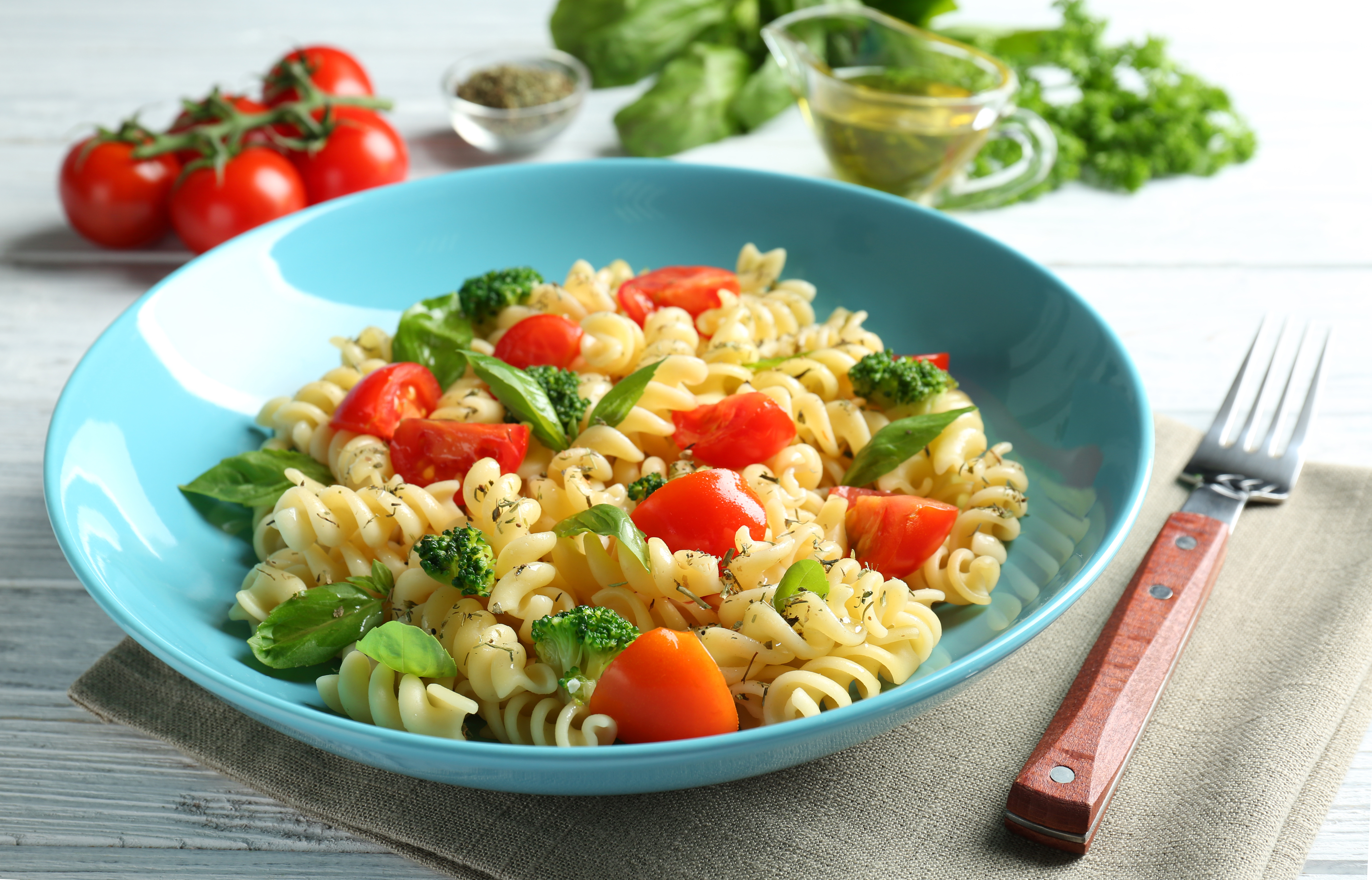 Plate of pasta salad with tomatoes and broccoli