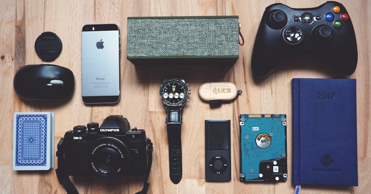 Flat lay of various modern gadgets, accessories, and tech items on wooden surface.