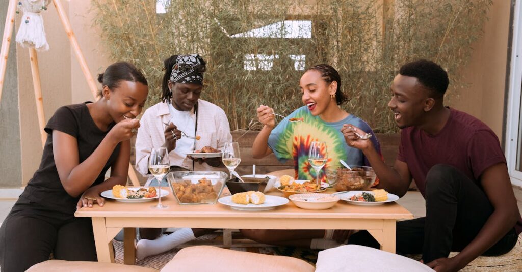 A joyful group of friends enjoying a meal together outdoors, showcasing diversity and friendship.