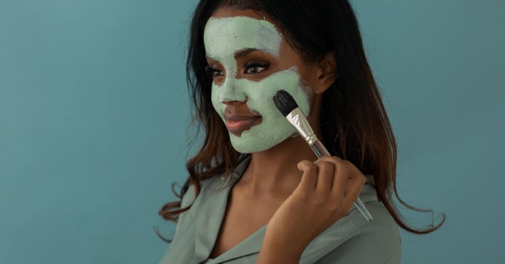 Smiling woman applies facial mask with a brush against a blue background. Black-owned businesses to shop for Juneteenth