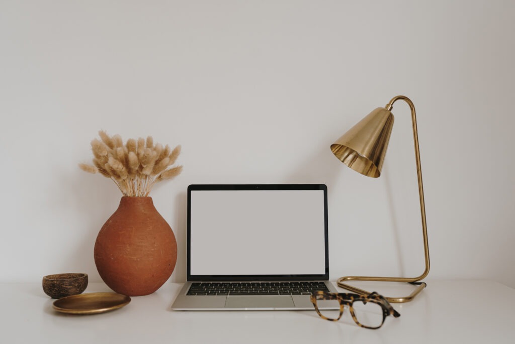 Home office desk workspace with glasses, flowers. Aesthetic bohemian decor.